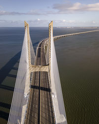 Bridge over sea against sky during sunset