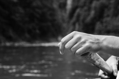 Cropped hands of man paddling in river