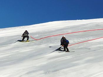 People skiing on snow covered landscape