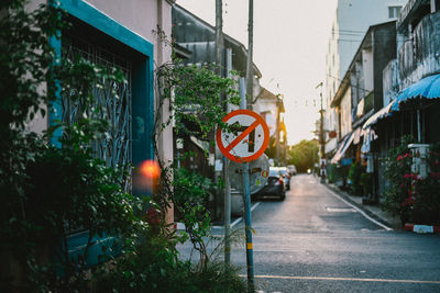 Road sign by buildings in city