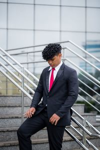 Full length of a young man standing against wall