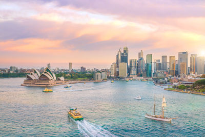 Panoramic view of sea and buildings against sky during sunset