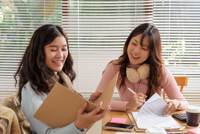 Portrait of young woman using laptop at home