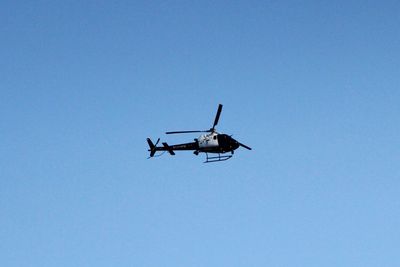 Low angle view of airplane against clear blue sky