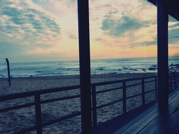 Scenic view of sea against cloudy sky at sunset