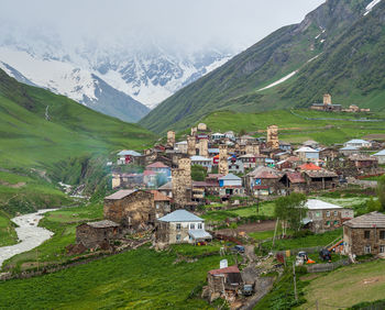 Aerial view of townscape by mountain against sky