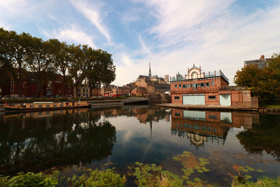 Reflection of nautical clubhouse in lake against sky