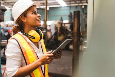 Side view of young woman using mobile phone
