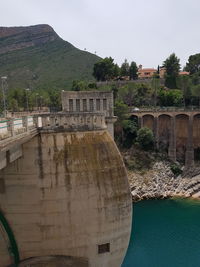 Arch bridge over river against sky