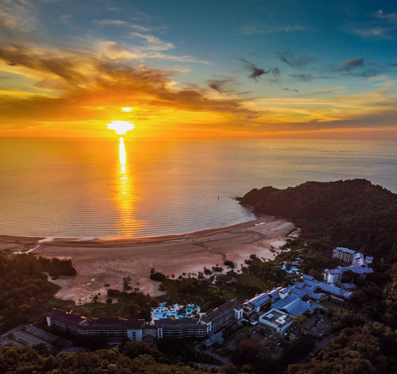 HIGH ANGLE VIEW OF SEA AGAINST BUILDINGS DURING SUNSET