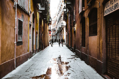 People walking on street amidst buildings in city