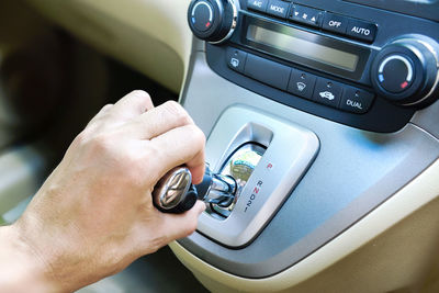 Cropped hand holding gearshift in car