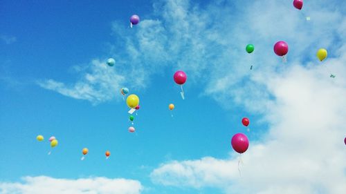 Low angle view of balloons flying against sky