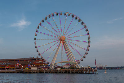 Ferris wheel in amusement park against sky