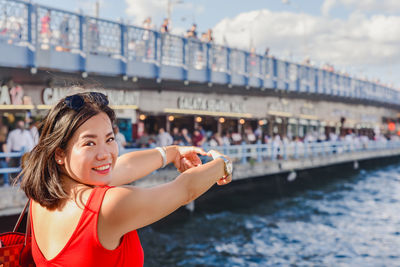 Portrait of a smiling young woman against boat in water