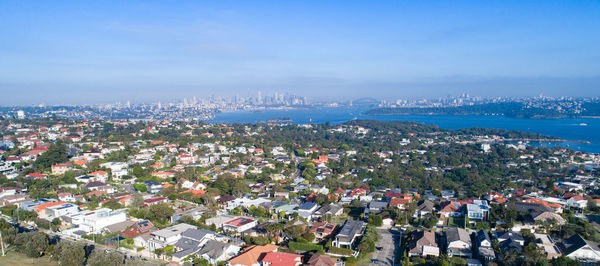 High angle view of townscape by sea against sky