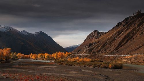 Road by mountain against sky during autumn