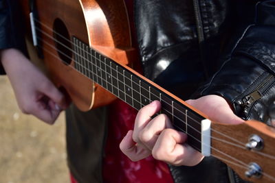 Midsection of person playing guitar