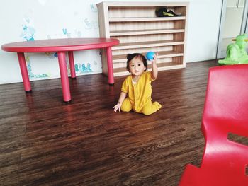 Portrait of boy playing with toy blocks on hardwood floor