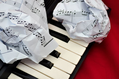 Close-up of crumpled sheet music on piano key