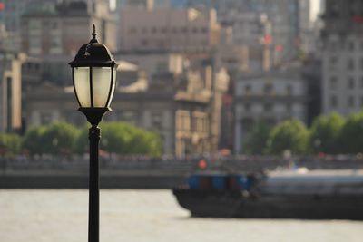 Close-up of street light against cityscape