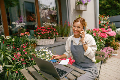 Young woman using laptop while sitting on table