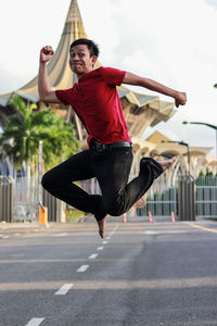 Portrait of man jumping on road