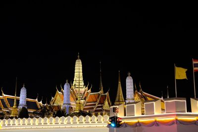 Illuminated buildings against sky at night