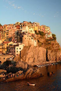 Buildings by sea against sky in city