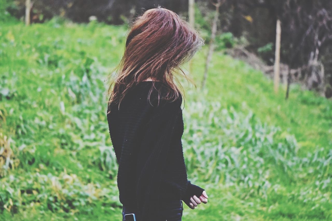 long hair, lifestyles, focus on foreground, standing, rear view, leisure activity, young women, casual clothing, person, grass, young adult, waist up, three quarter length, field, brown hair, side view, outdoors