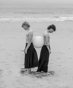 Rear view of woman standing at beach