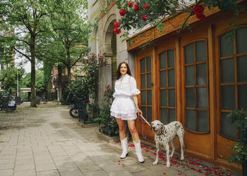 Rear view of woman with dog on street