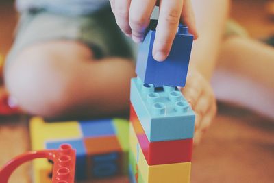 Close-up of human hand and toy block