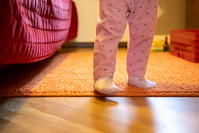 Low section of girl standing on hardwood floor