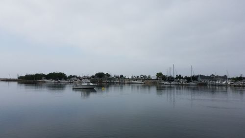 Sailboats moored in lake against sky