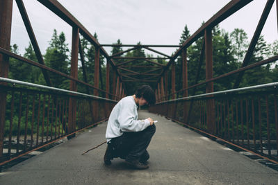 Side view of man crouching outdoors