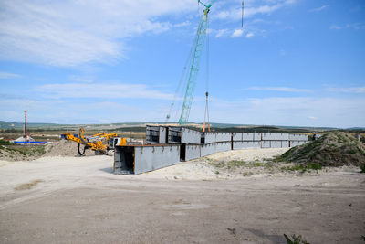 Construction site by road against sky