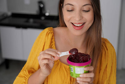 Portrait of young woman holding ice cream