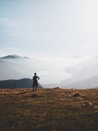 Woman standing on mountain against sky