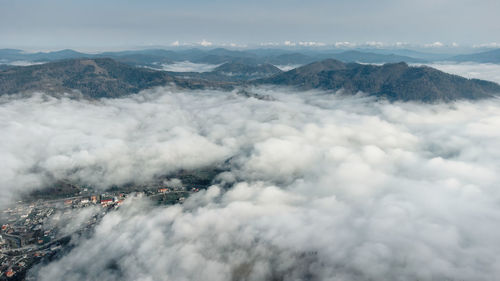 Above the clouds. foggy layered mountain landscape with a city in carpathians, ukraine.