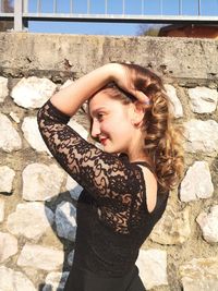 Portrait of woman standing against wall