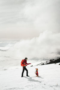 Full length of woman skiing on snow covered landscape