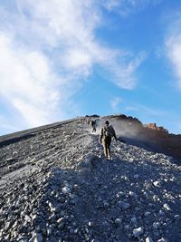 People standing on mountain against sky