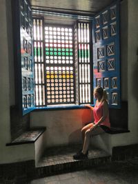 Woman looking away while sitting in building