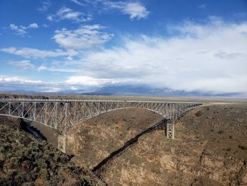 Arch bridge over land against sky