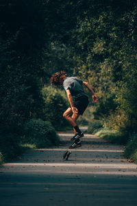 Side view of man jumping on road