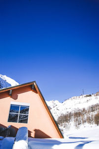 Snow covered landscape against clear blue sky