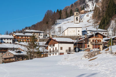 Winter in sauris di sotto. traditional architecture under the sun and snow