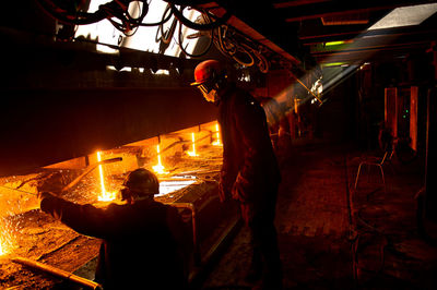 Workers pouring molten metal in foundry