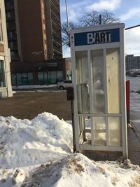 Snow covered buildings against sky during winter